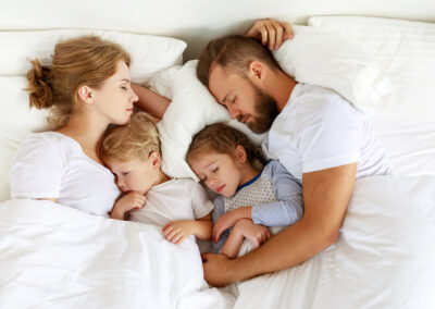 family parents and children sleeping in bedding Australia bed