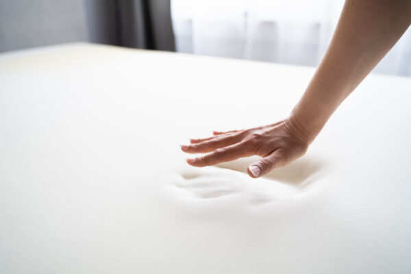 Hand making a hand print to Testing Orthopedic Memory Foam Core Mattress